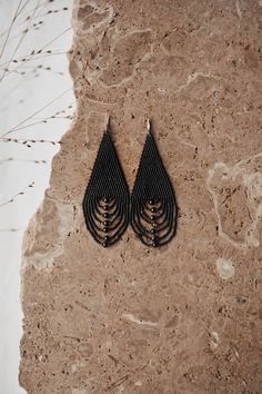 two pairs of earrings sitting on top of a stone floor