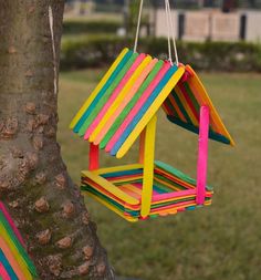 a colorful bird house hanging from a tree