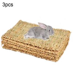 a small rabbit sitting on top of a pile of woven material with the words 5 mats below it