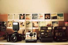 several polaroid cameras sitting on top of a shelf