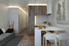 a living room and kitchen area in a small apartment with white walls, wood flooring and exposed lighting