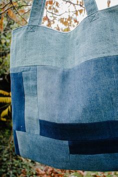 a blue tote bag hanging from a tree