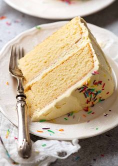 a slice of cake on a white plate with sprinkles and a fork