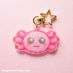 a pink keychain with an angel design on it's side and a star hanging from the top