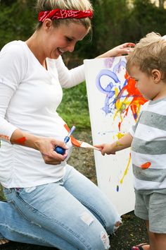 a woman and child painting on an easel