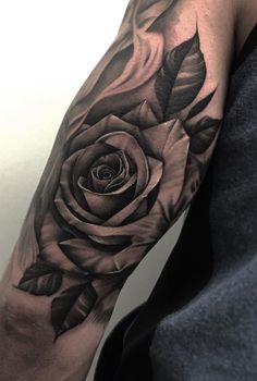 a black and white rose tattoo on the arm