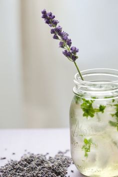 a jar filled with water and lavender sprigs