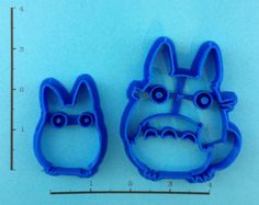 two cookie molds shaped like animals on a blue background with ruler in the foreground