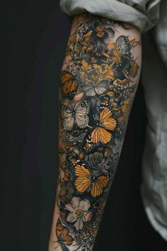 a woman's arm with butterflies and flowers tattooed on the side of her leg