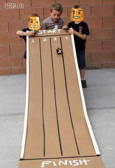 two boys holding up a cardboard finish line