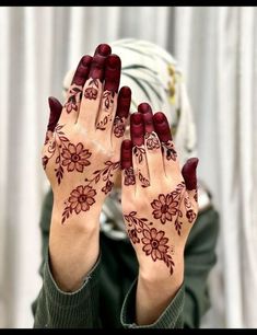 a woman holding her hands up with hendi designs on it's palms and fingers