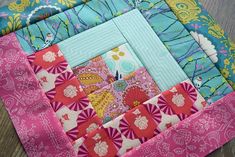 a colorful patchwork quilt on top of a wooden table