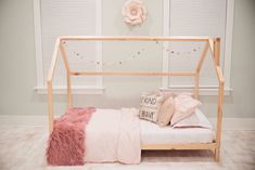 a bed with pink and white pillows on it