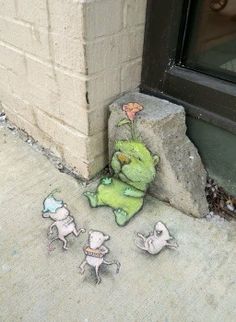 there is a green stuffed animal on the sidewalk