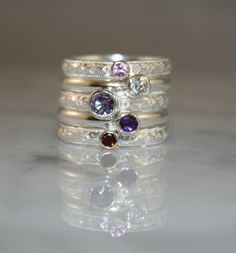 "Stacking Family Ring made with Sterling Silver and Gemstones. Made to Order This custom made set of stacking rings nestle very nicely beside one another. The rings are stunning with different colors of gemstones so even if you don't want a family ring, I would be happy to work with you to create a beautiful and unique ring just for you. This custom made set of family rings is made with 5 separate solid sterling silver bands, sterling silver bezels and gemstones. Each individual ring band measur Sterling Silver Stackable Rings With Multi-stone, Silver Stackable Rings With Gemstone Accents, Sterling Silver Multi-stone Stackable Promise Rings, Silver Stackable Gemstones For Anniversary, Silver Stackable Amethyst Ring For Anniversary, Stackable Sterling Silver Rings With Accent Stones, Fine Jewelry Sterling Silver Stackable Rings With Gemstone Accents, Sterling Silver Multi-stone Stackable Rings For Wedding, Silver Stackable Rings With Multi-stone