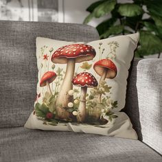 a pillow with mushrooms on it sitting on a couch