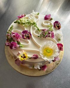 a cake decorated with flowers on a gold plate