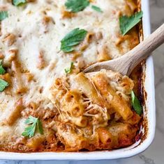 a casserole dish with meat, cheese and parsley on the top is ready to be eaten