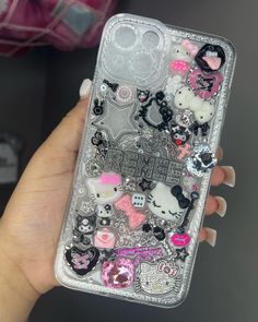 someone is holding up their phone case with hello kitty stickers all over it,