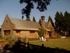 a house with a metal roof and two lawn chairs in front of the yard area