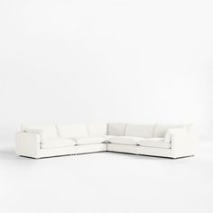 a white sectional couch sitting on top of a white floor