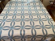 a bed with a blue and white quilt on it