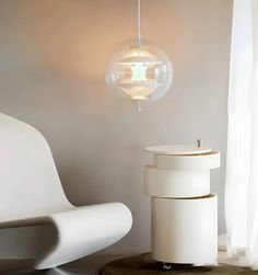 a white chair sitting next to a round light fixture