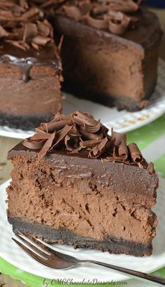 two slices of chocolate cake on plates with forks