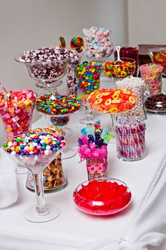 a table topped with lots of candy and candies on top of glass vases