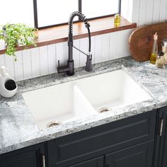 two white sinks in a kitchen under a window