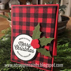 a christmas card made with plaid paper and holly berry dieing on top of evergreen branches