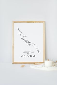 a framed poster with the words you and me on it next to a glass of milk