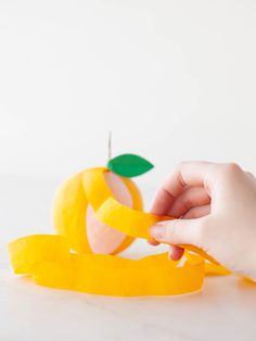 someone is peeling an apple with a ribbon around it to make the fruit look like they have been cut in half