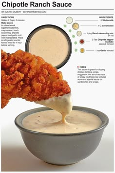 a fried chicken is being dipped with ranch sauce in a gray bowl on a white background