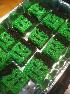 there are many square cakes that have green frosting on them, sitting on a baking sheet