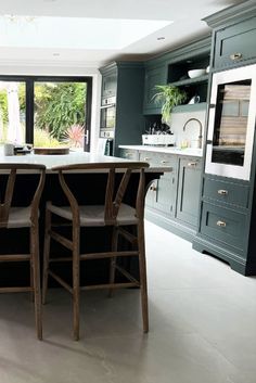 Our Crystal Lustre Ivory porcelain floor tiles used in an open-plan green shaker kitchen and dining space