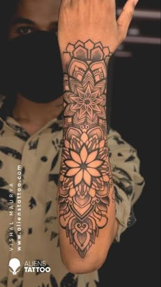 a man's arm with a tattoo on it and a flower design on the wrist