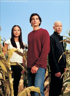 an autographed photo of two people standing in a corn field with the sky behind them