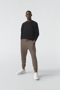 Made with 100%  Cotton for breathability and comfort, the Huron Pant has a rib-knit waist and cuffs for a tailored fit and a zippered back pocket. Casual Loungewear Pants With Minimal Stretch, Sporty Pants With Ribbed Cuffs For Work, Men Parka, Baby Outerwear, Mens Parka, Snow Pants, Back Pocket, Bottom Clothes, Black Label