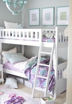 a white bunk bed sitting in a bedroom next to a table and chairs with pictures on the wall