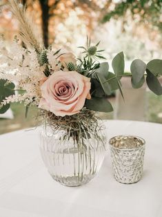 a vase filled with flowers sitting on top of a table next to a candle holder