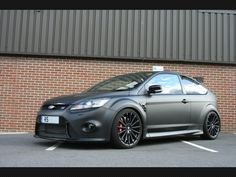 a grey car parked in front of a brick building