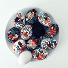 an arrangement of painted eggs in a bowl