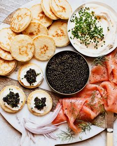 an assortment of food on a plate with crackers and other foods in bowls next to it