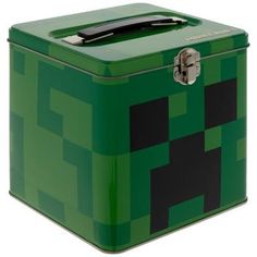 a green box with black squares on the front and sides, has a metal latch at the top