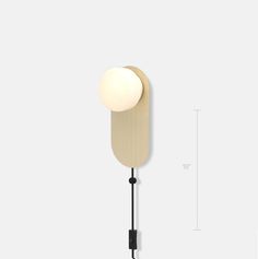 a wall light with a white ball hanging from it's side and a black cord on