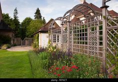 a garden with lots of flowers next to a house