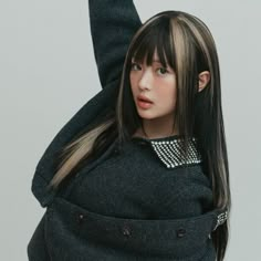 a woman with long hair and bangs wearing a black sweater is posing for the camera