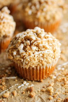 a muffin with white frosting and sprinkles sitting on a table