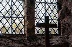 a cross sitting in front of a window